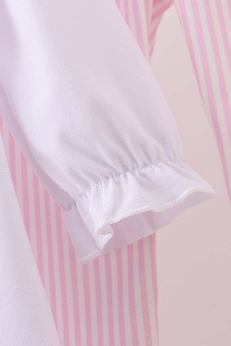 Close-up of a white blouse with pink stripes on a light pink background