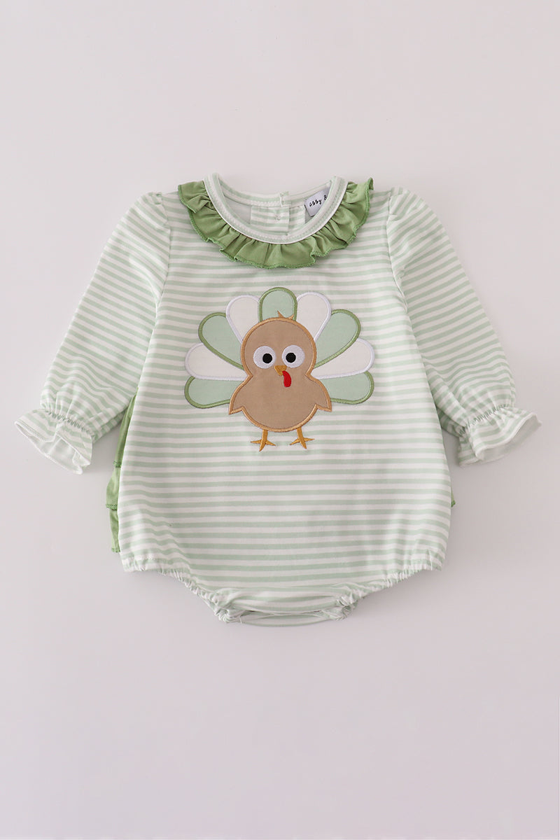 Green and white striped baby romper with a turkey applique on a light gray background