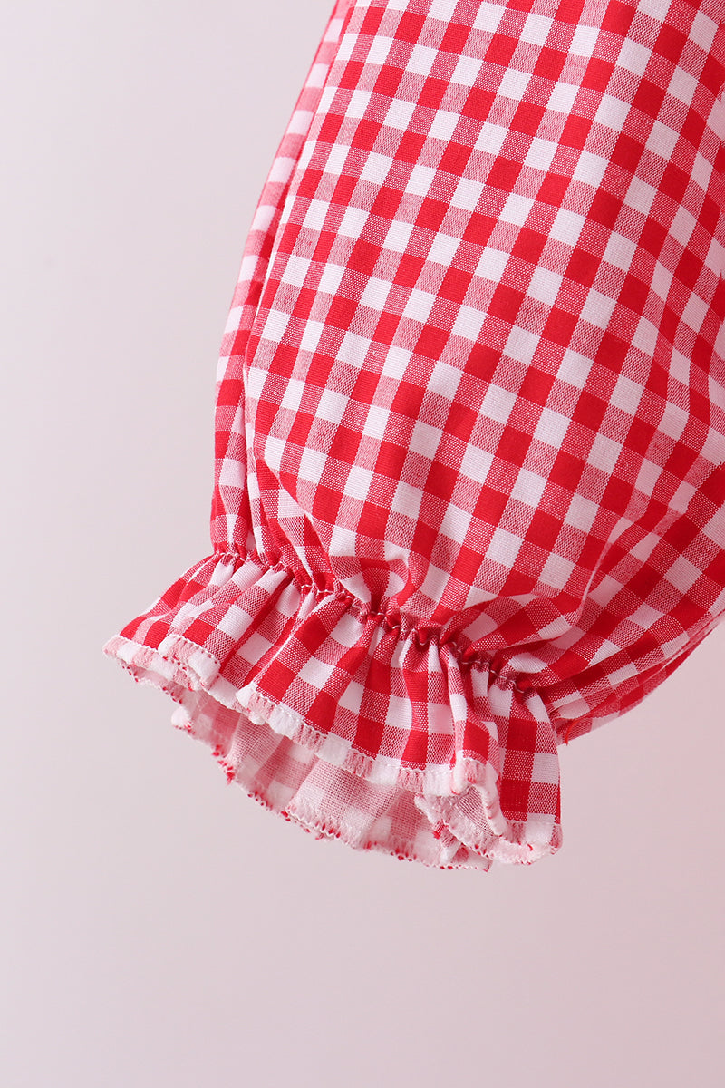 Red and white checkered fabric with ruffled edge on a light gray background