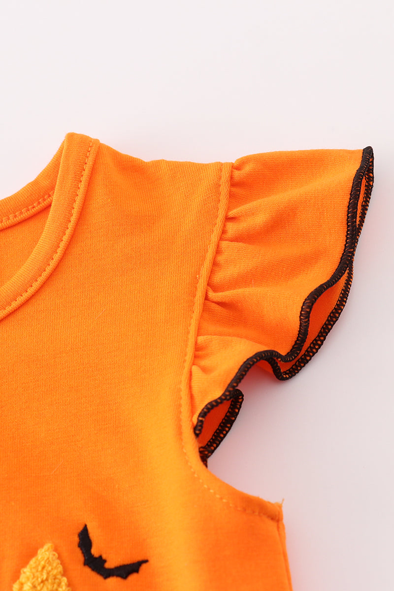 Close-up of an orange baby outfit with black trim on a white background