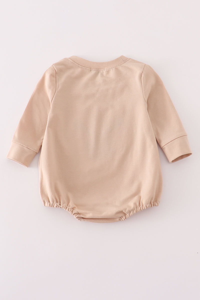 Beige baby romper on a white background