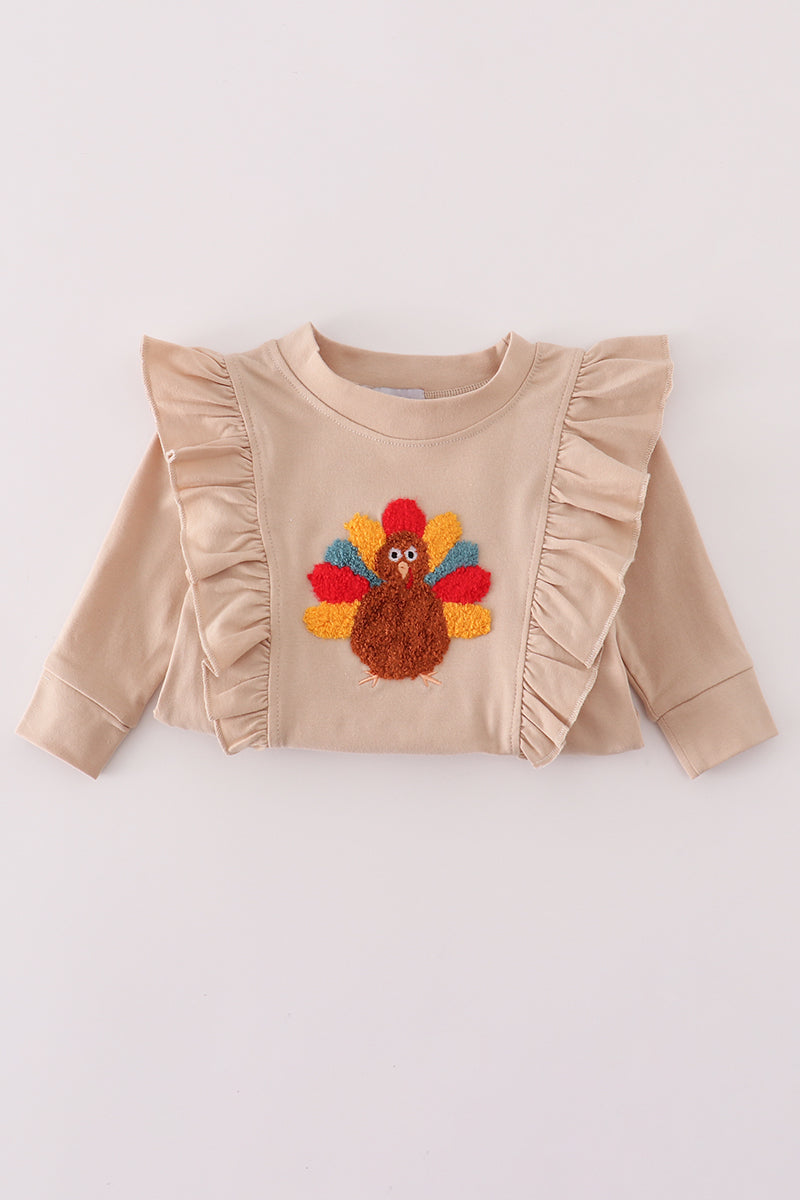 Beige sweater with a embroidered turkey design on a white background