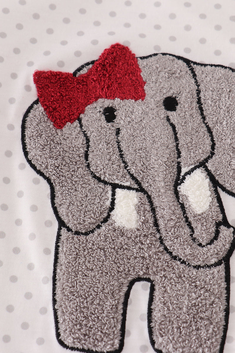 Gray elephant with a red bow on a polka dot background