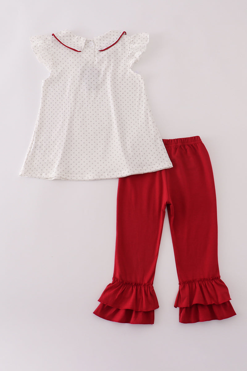 White top with red trim and red ruffled pants on a light gray background