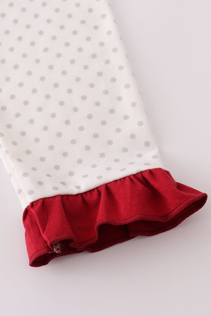 Children's outfit with white polka dot top and red ruffled bottom on a light gray background