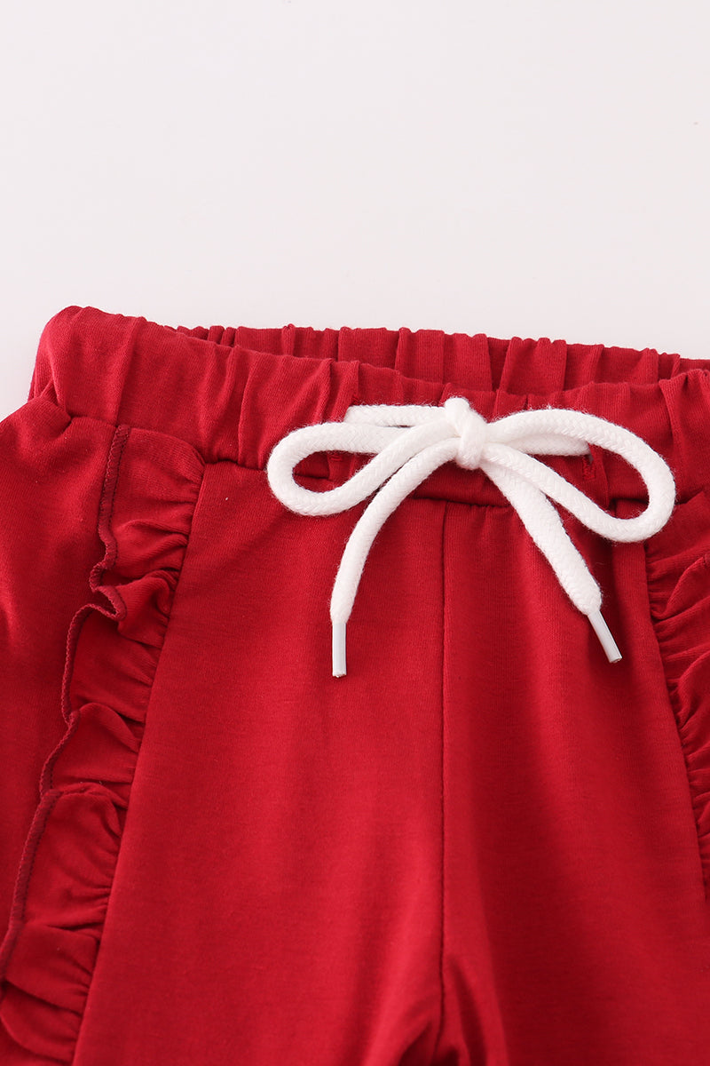 Red pants with white drawstring on a light gray background