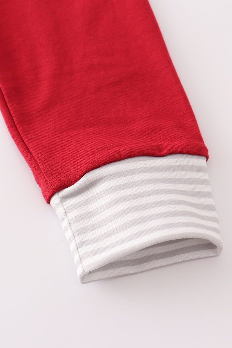 Close-up of red fabric with white trim on a light gray background