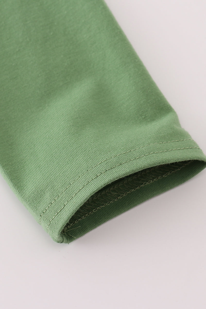 Close-up of a green fabric edge on a light gray background