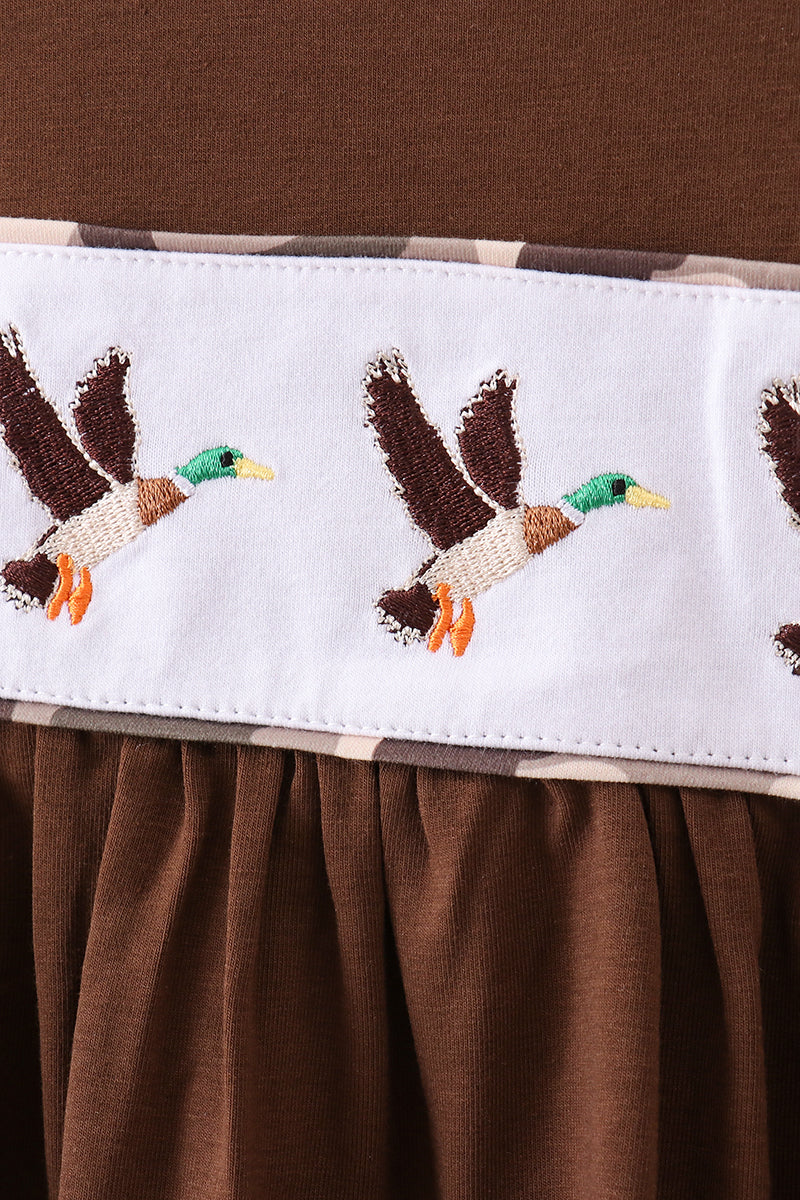Brown fabric with embroidered ducks on a white border