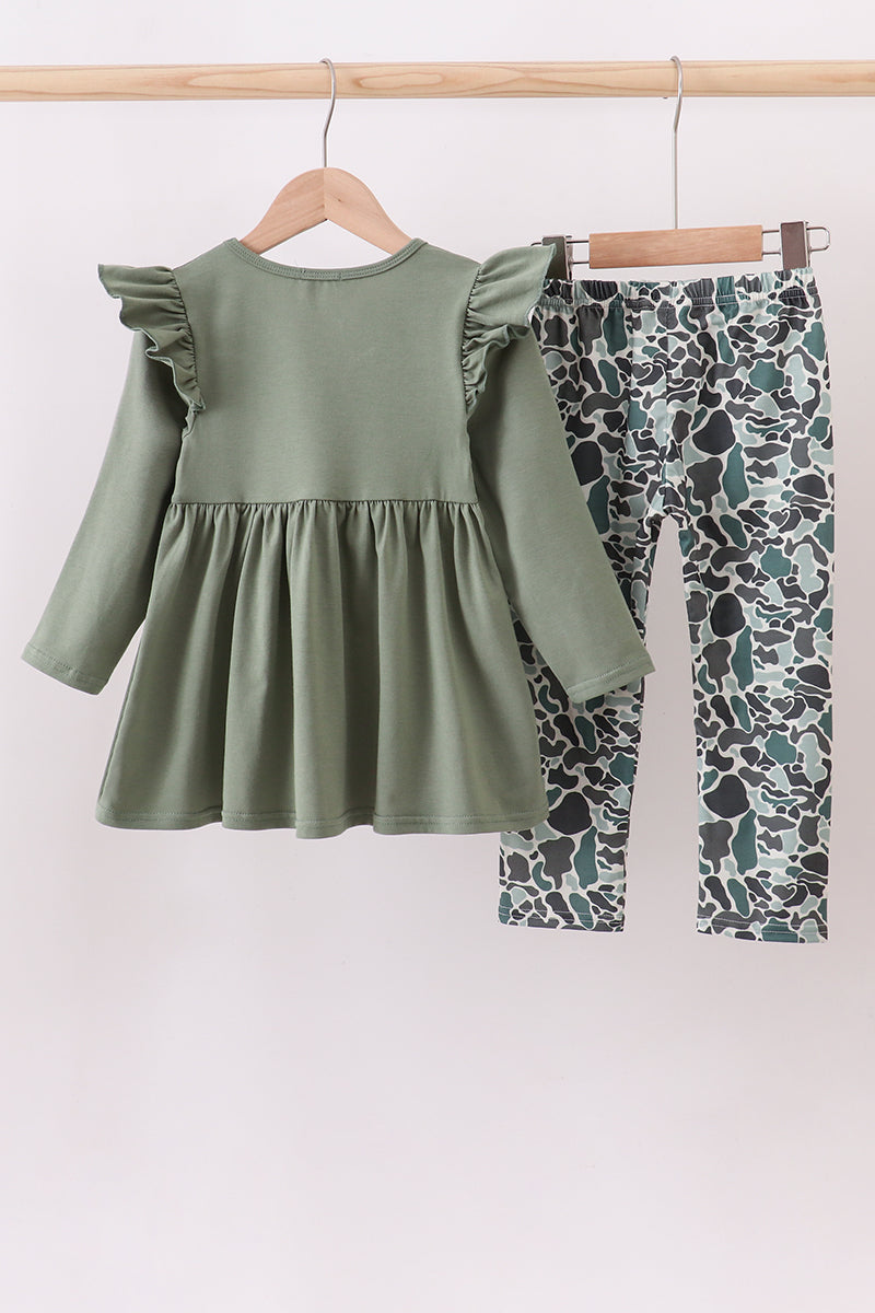 Green dress with ruffled sleeves and patterned leggings on a hanger against a white background