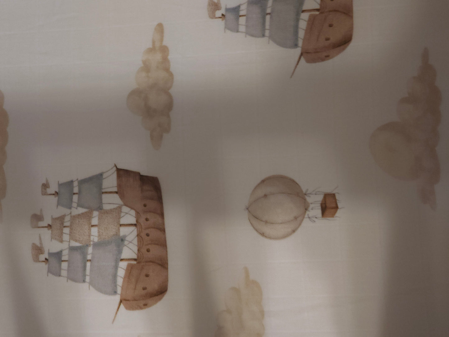 Decorative wall stickers of ships and a hot air balloon on a plain wall.