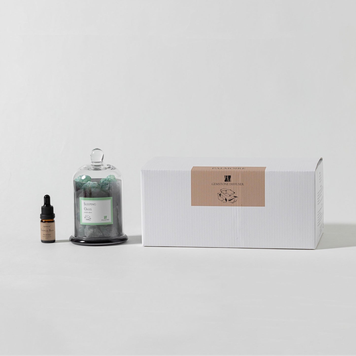 Bottle of essential oil, dropper bottle, and a box on a white surface