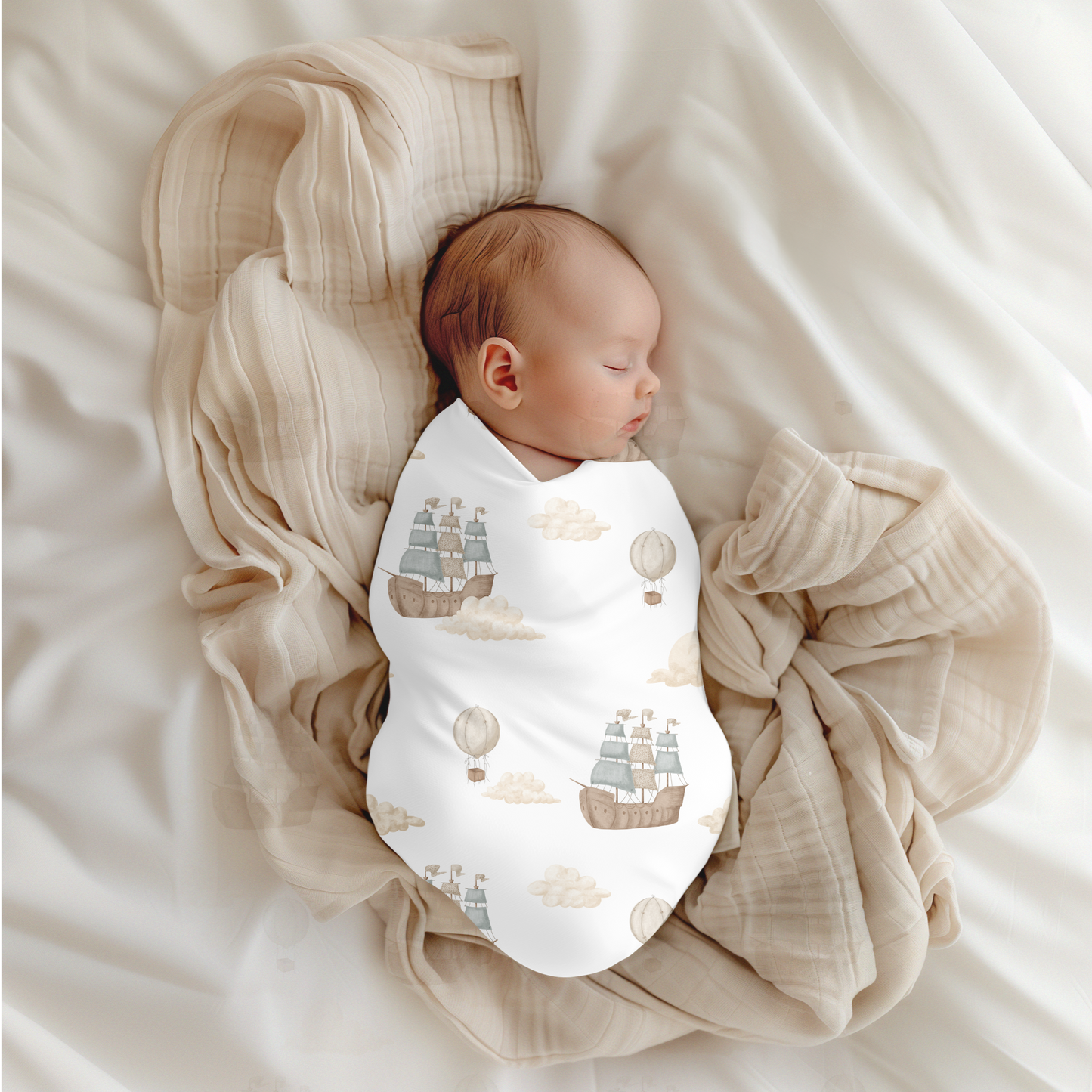 Newborn baby swaddled in a blanket with ship and cloud pattern on a soft beige background