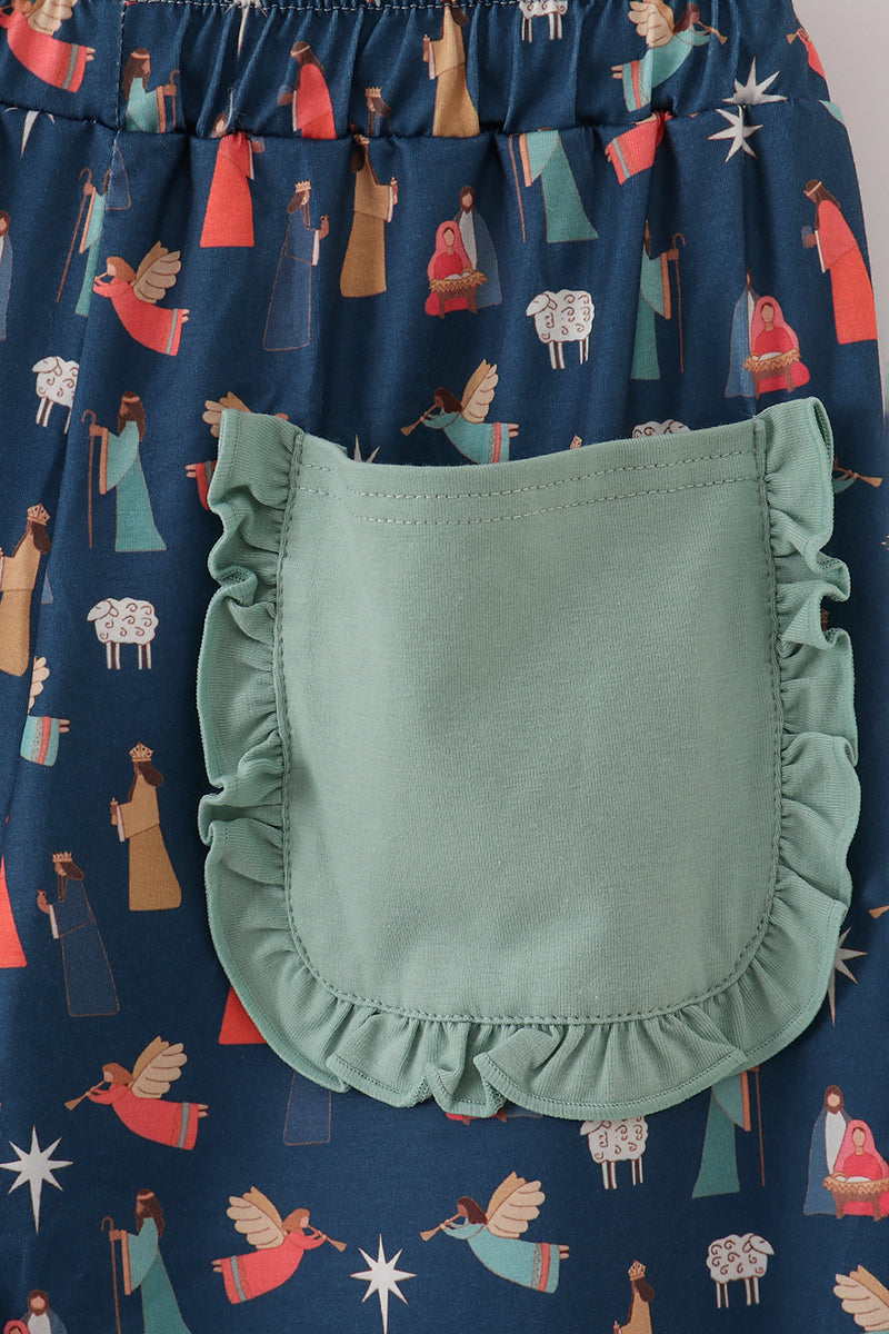 Green ruffled pocket on a navy fabric with angel pattern