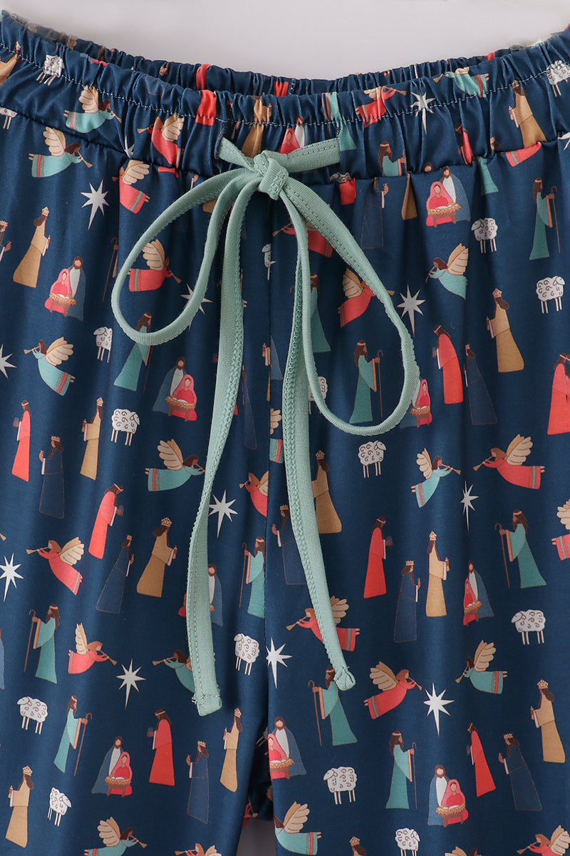 Navy blue pajama pants with colorful pattern and green drawstring on a white background