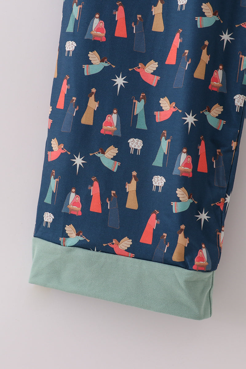 Navy blue fabric with nativity scene pattern and light green hem on a white background