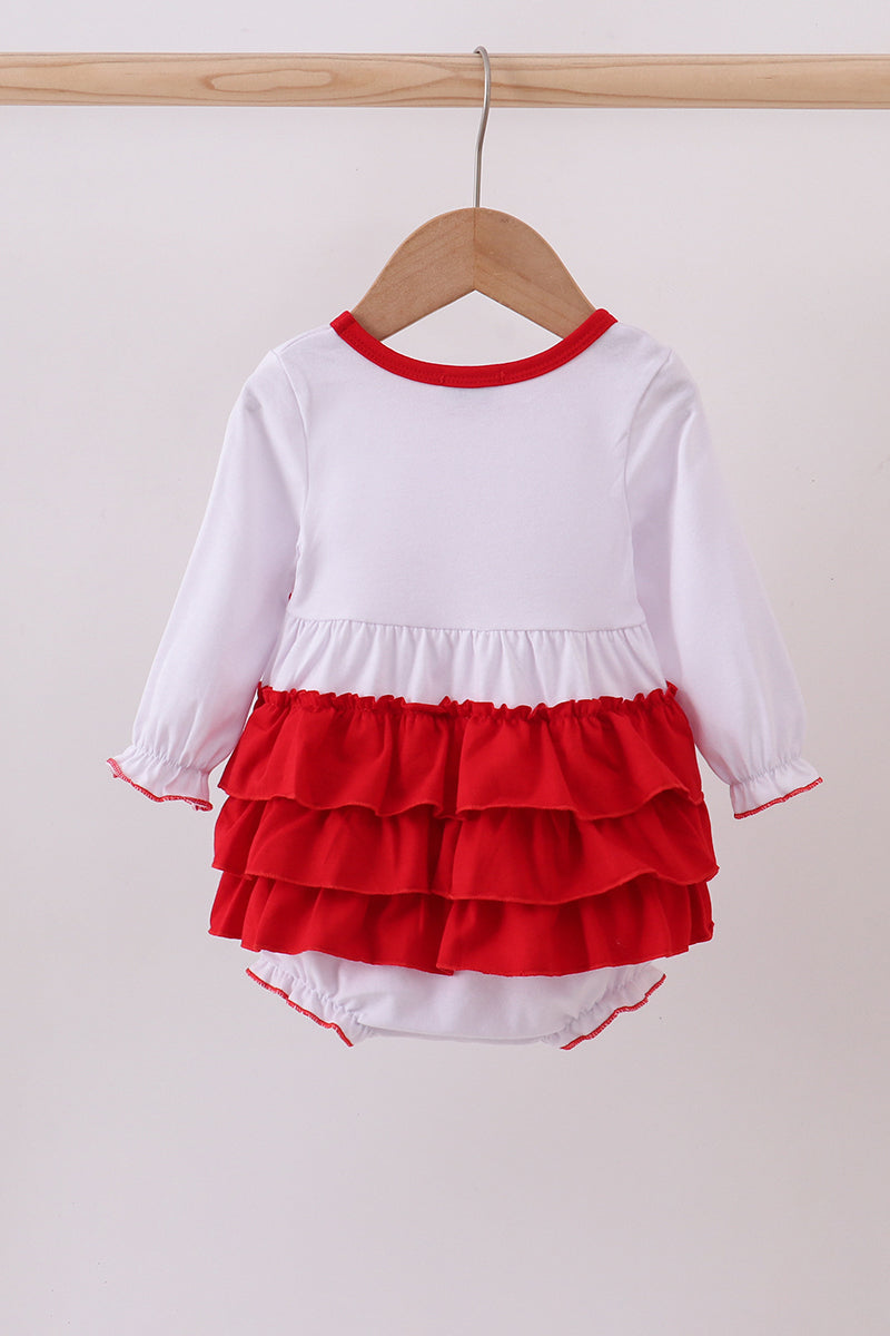 White long-sleeve top with red ruffled layers and matching red diaper on a hanger against a white background.