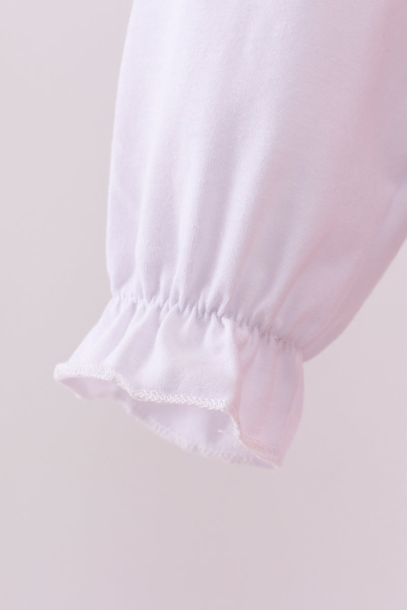 Close-up of a light pink fabric with a gathered hem on a soft pink background