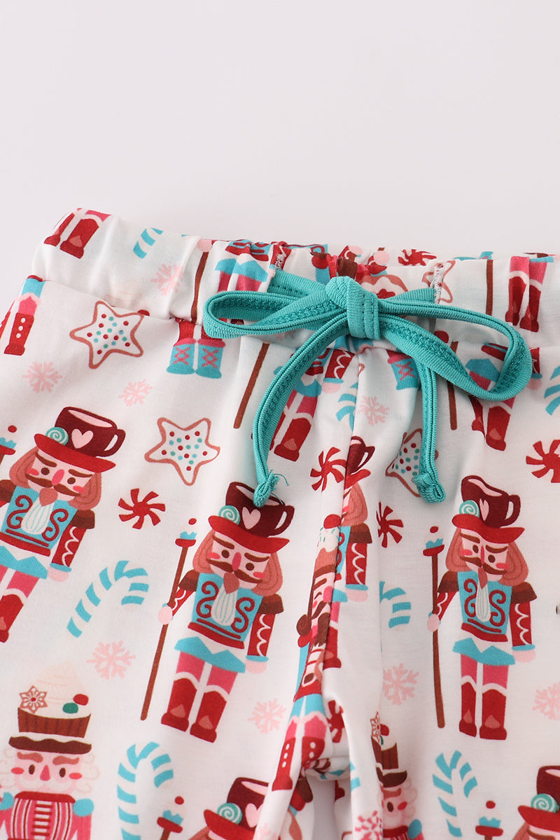 Children's pajama pants with nutcracker and candy cane pattern on a white background
