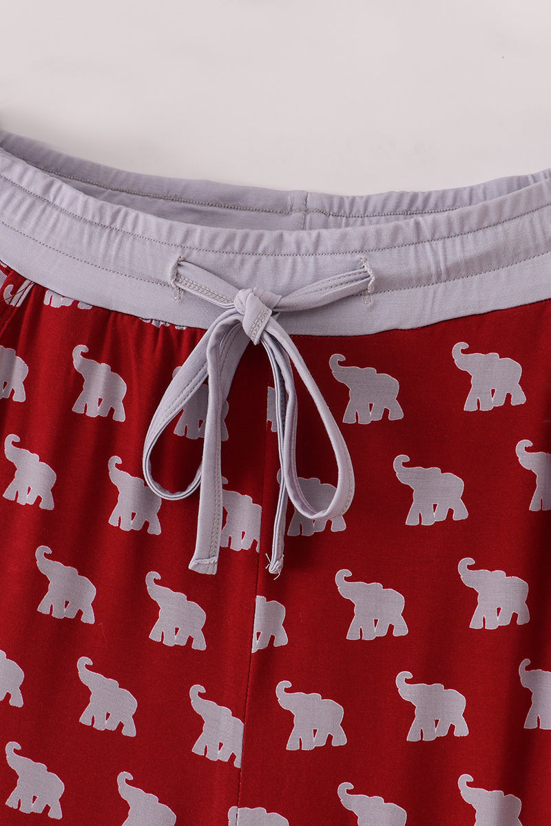 Red shorts with white elephant pattern and white waistband on a light gray background