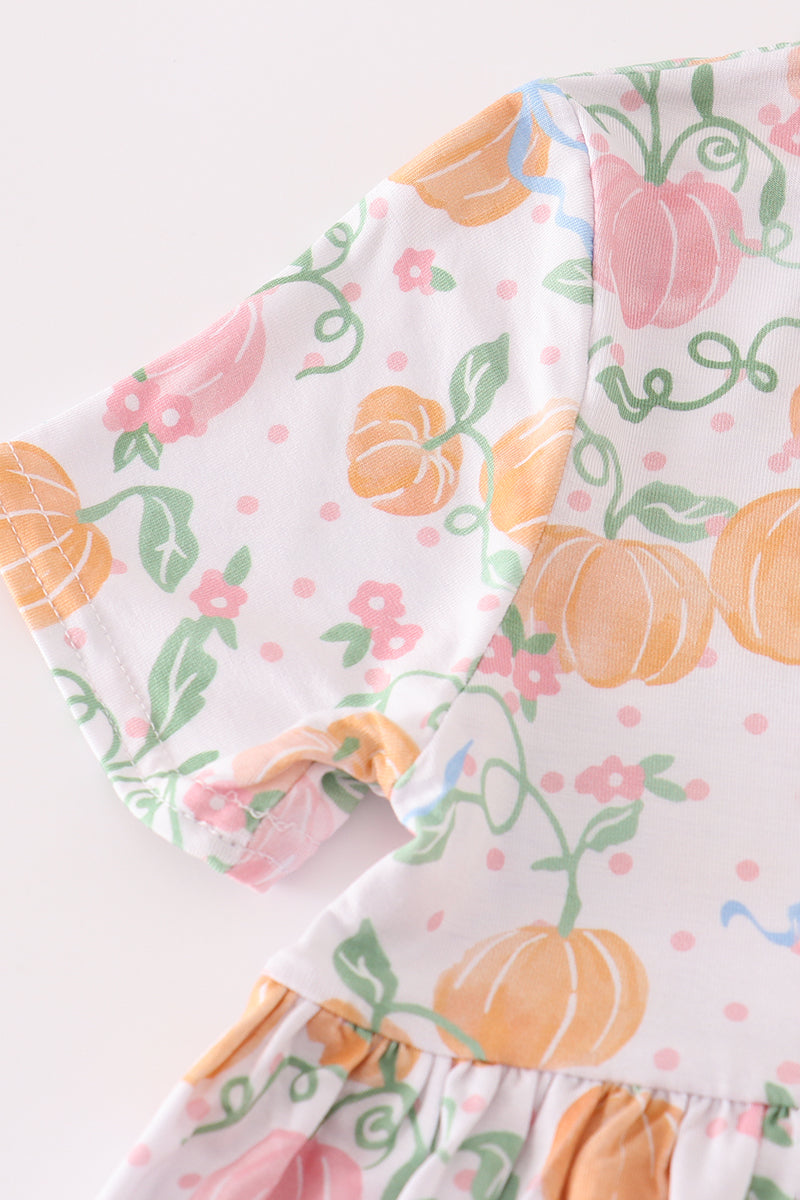 Floral and pumpkin patterned fabric on a white background