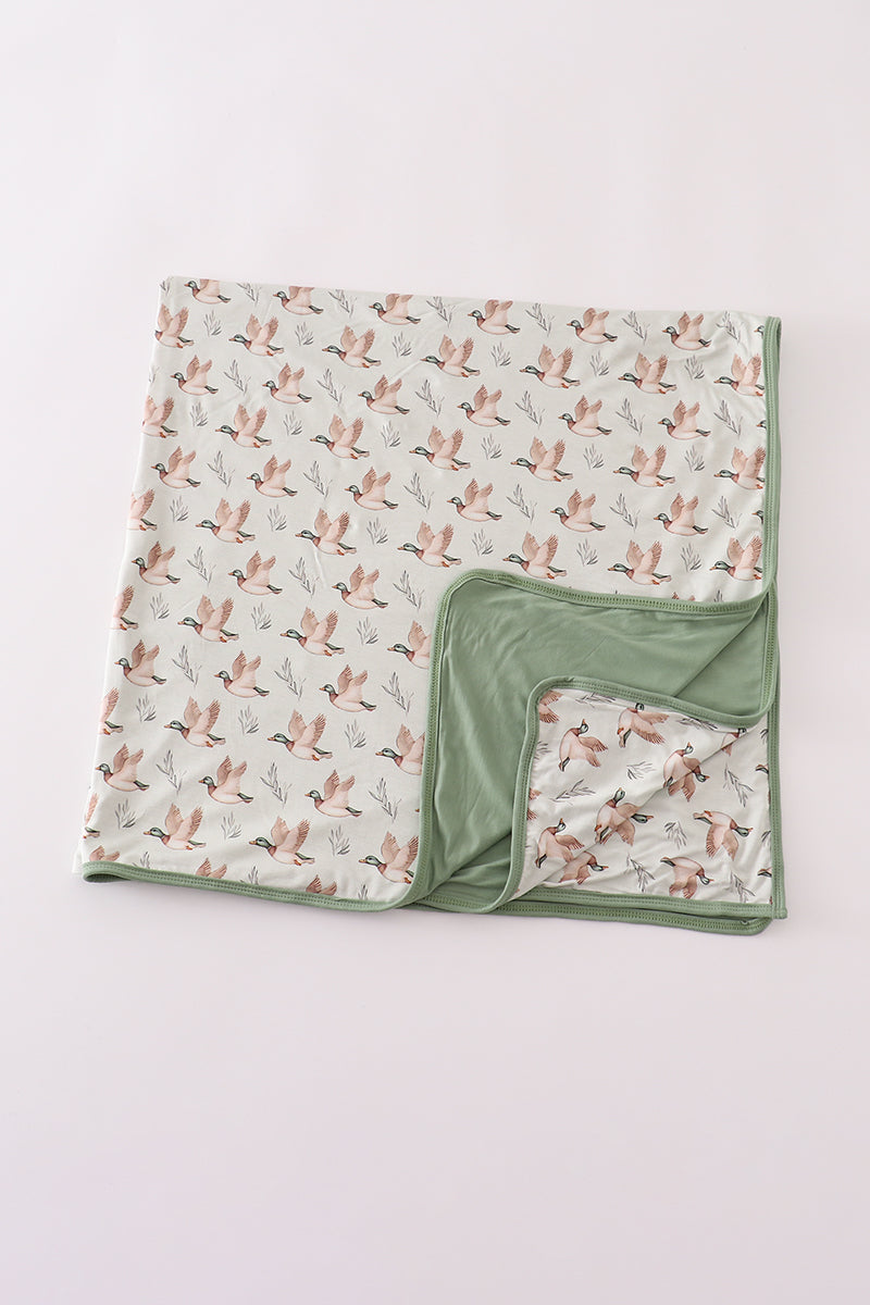 Folded blanket with bird pattern on a light gray background