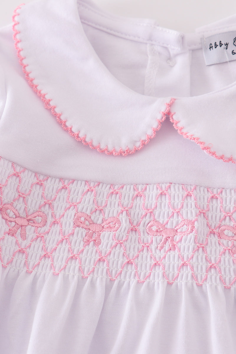 White dress with pink embroidery and trim, featuring a brand label.