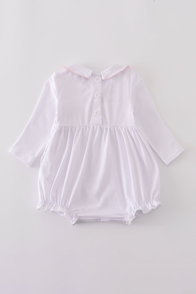 White baby romper with long sleeves on a light gray background