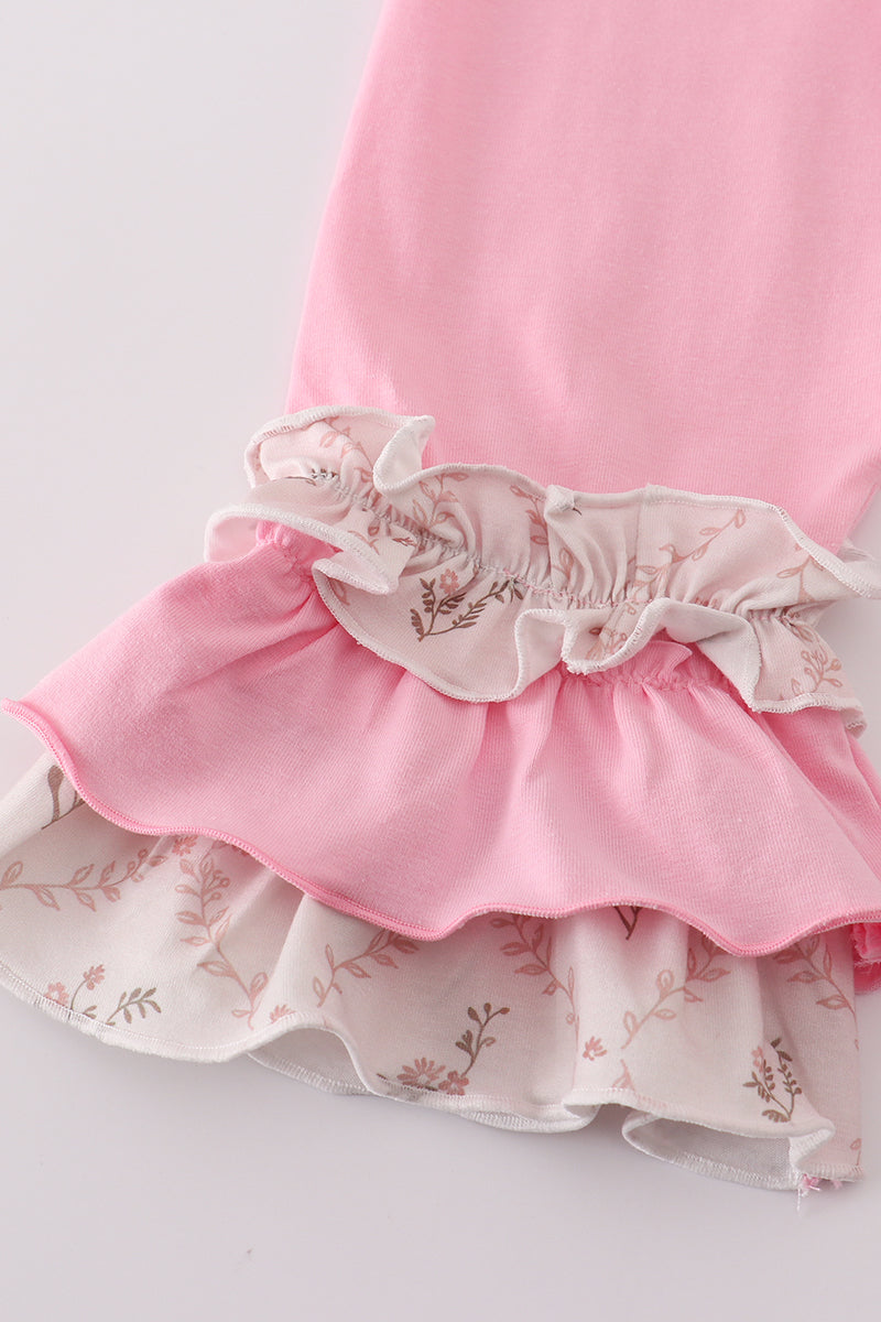 Close-up of a pink dress with floral details on a light background