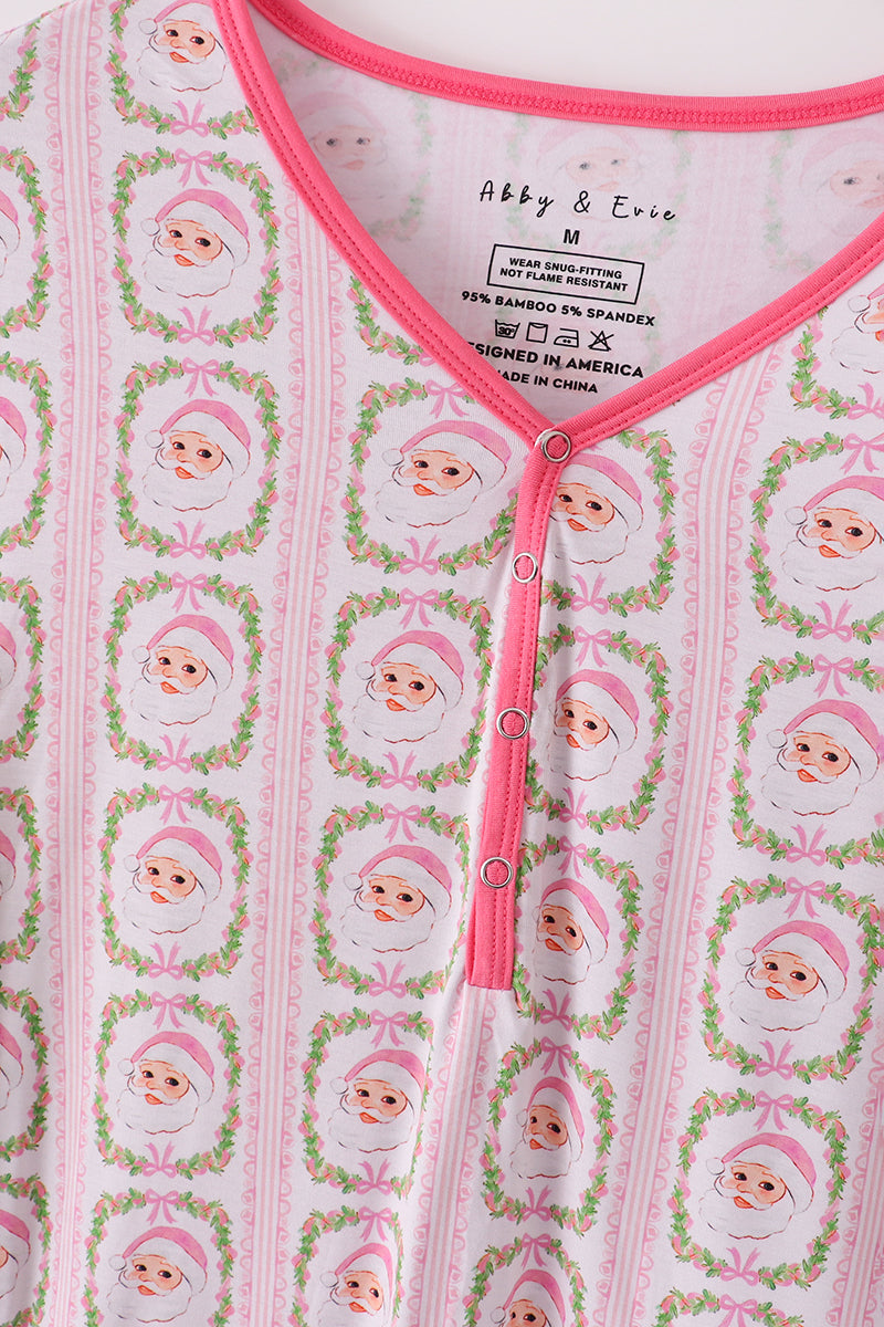 Baby outfit with pink buttons and a pattern of cartoon characters on a white background.