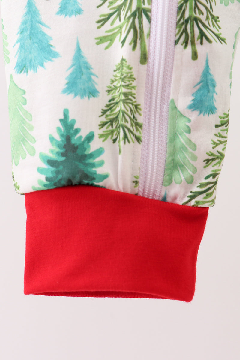 Close-up of a children's outfit with a forest pattern and red trim on a white background