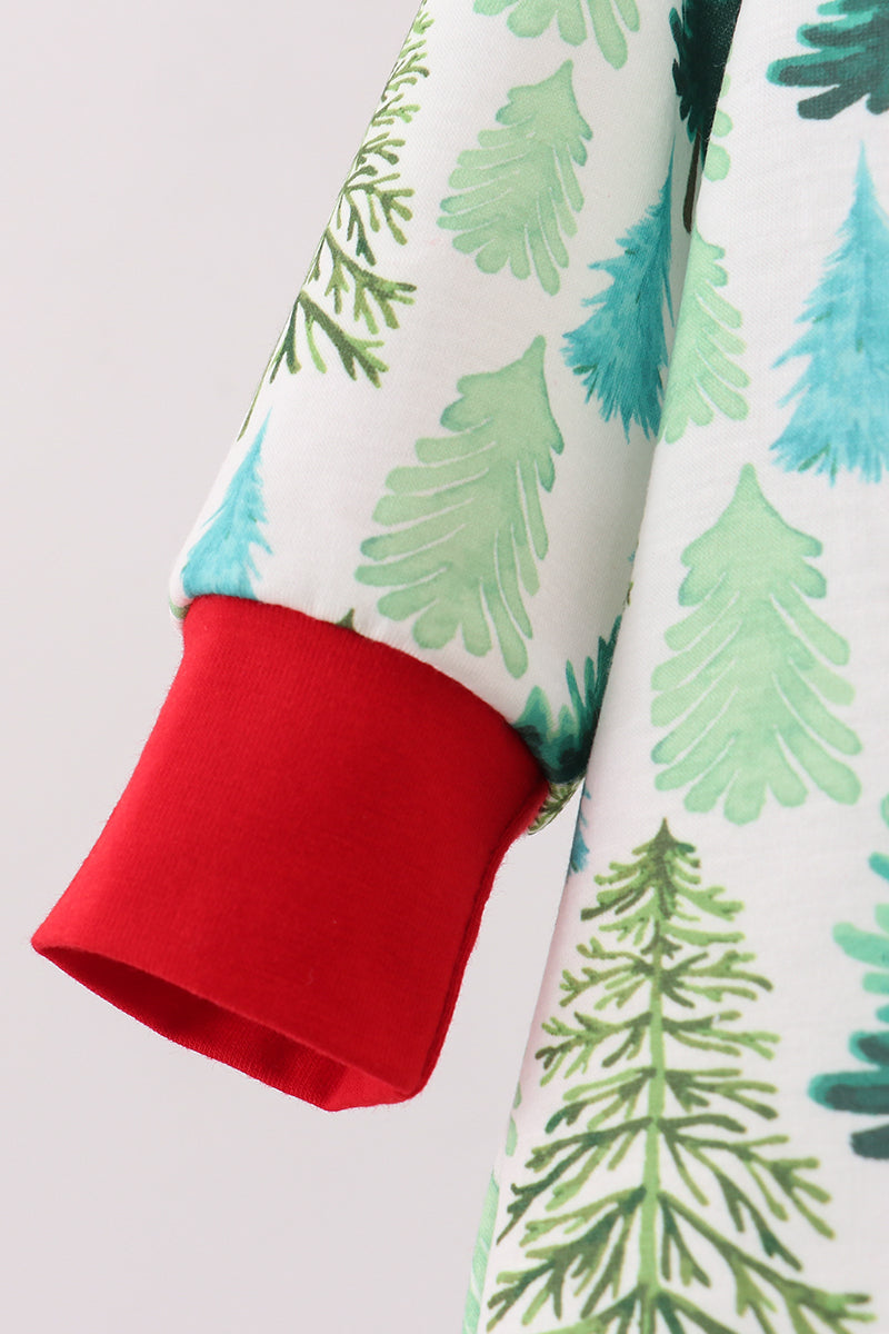 Close-up of a fabric with green tree patterns and a red edge on a white background