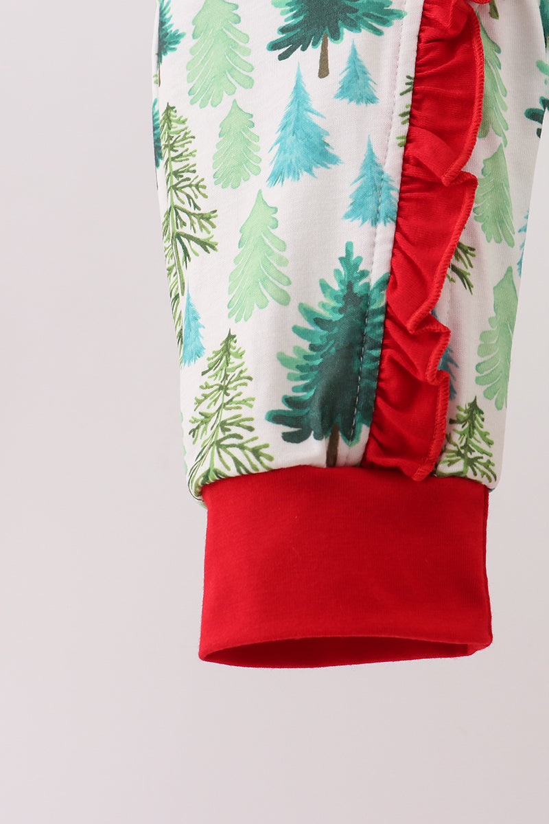 Close-up of a garment with red trim and green tree pattern on a white background