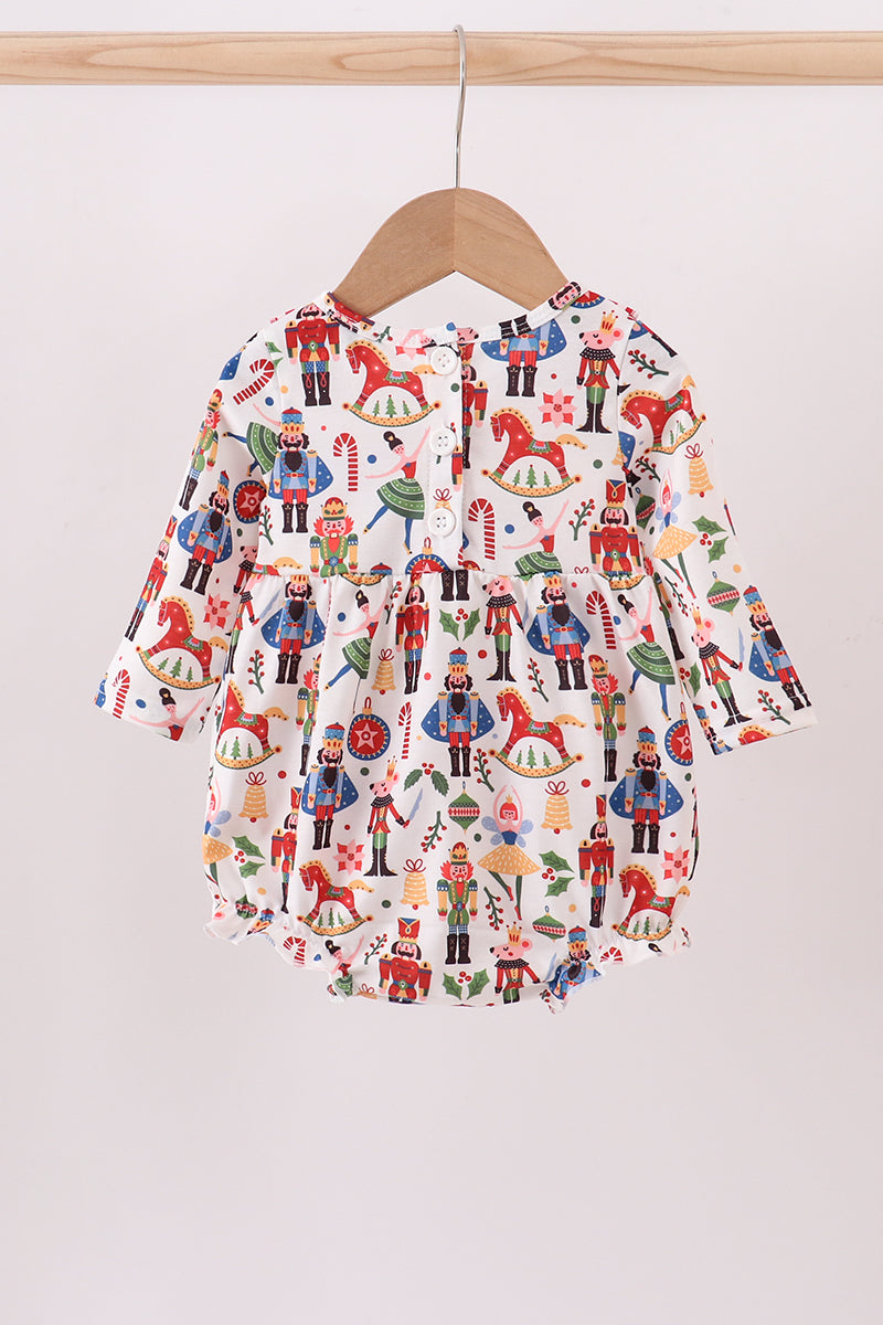 Baby romper with colorful pattern on a wooden hanger against a white background