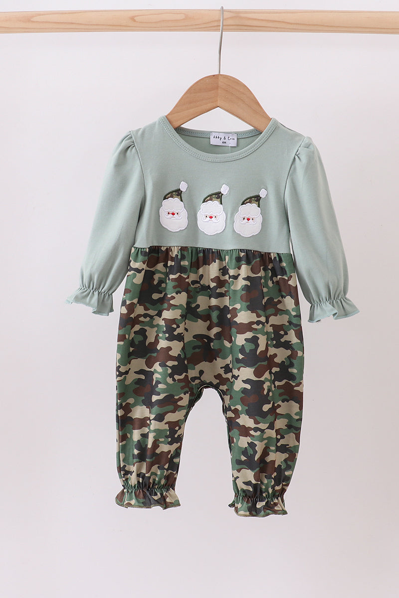Two-piece outfit with green top and camouflage pants on a hanger against a white background
