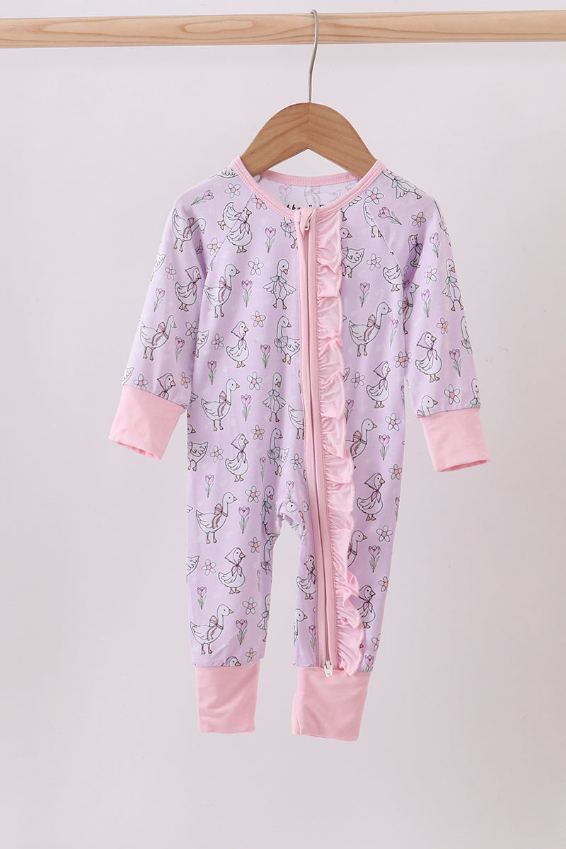 Pink baby onesie with ruffle details on a wooden hanger against a white background