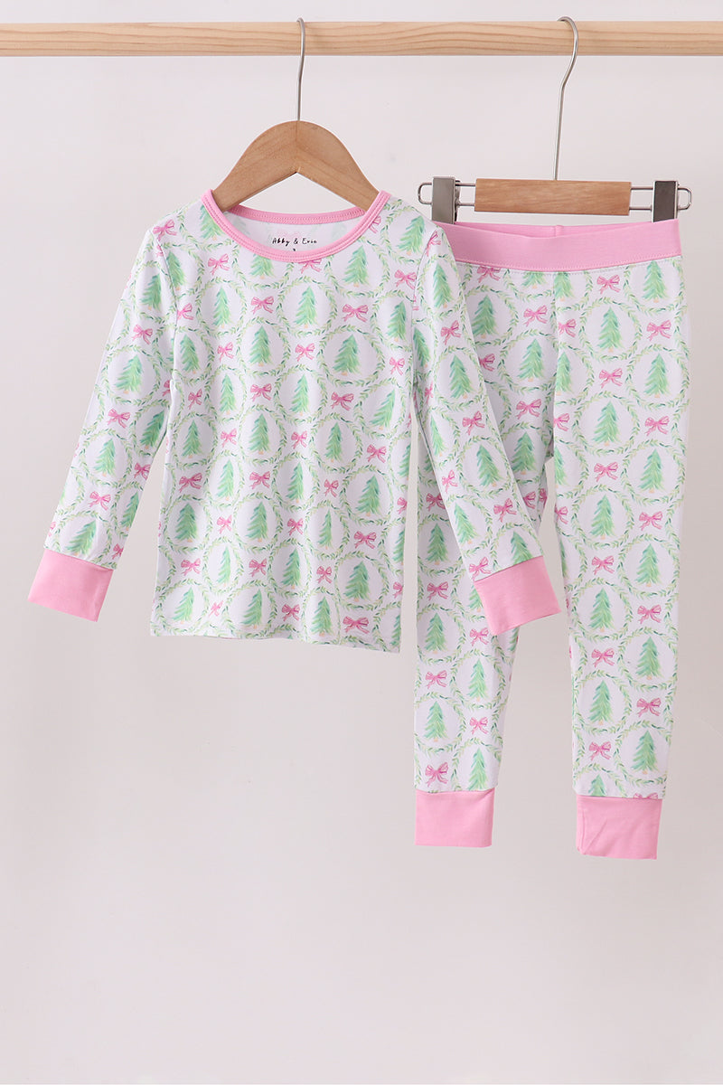Children's pajama set with cactus and bow pattern on a hanger against a white background