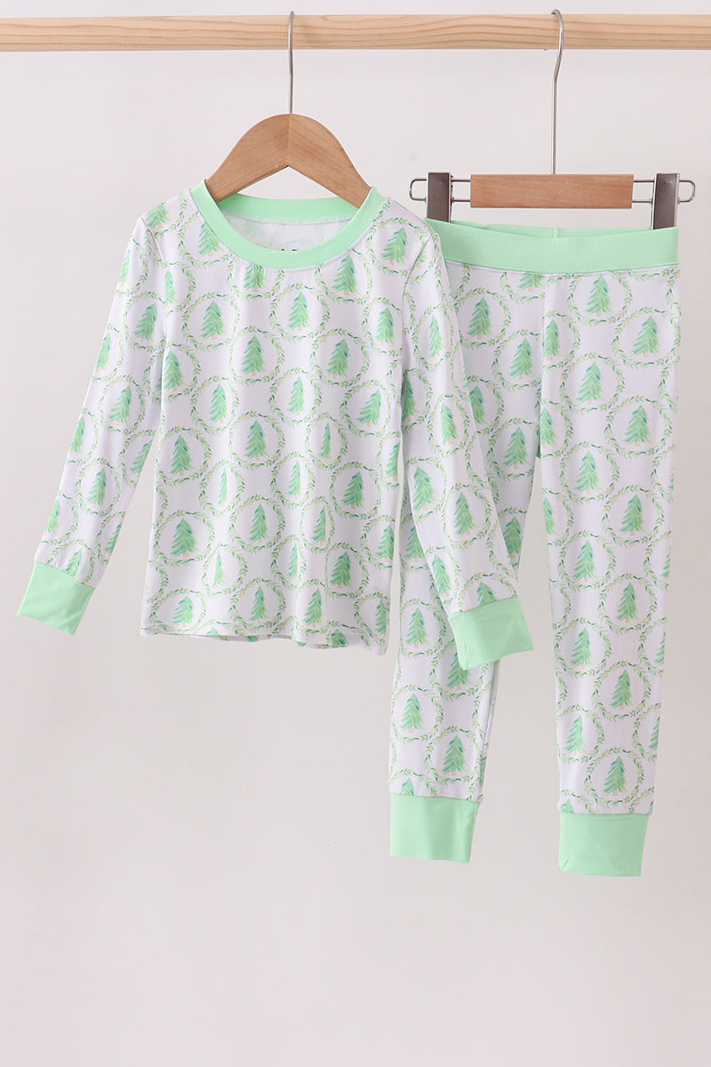Children's pajama set with green and white pattern on a hanger against a white background