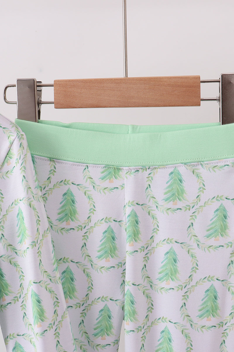 Skirt with green tree pattern on a hanger against a white background