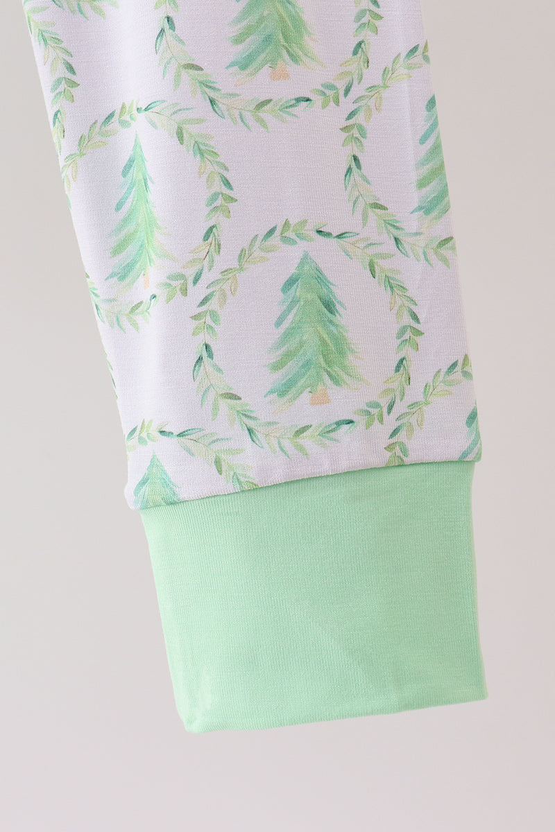Pants with green tree pattern and solid green bottom on a light gray background