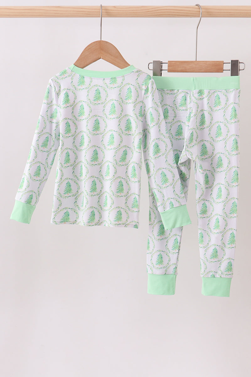 Children's pajama set with green and white pattern on a hanger against a white background