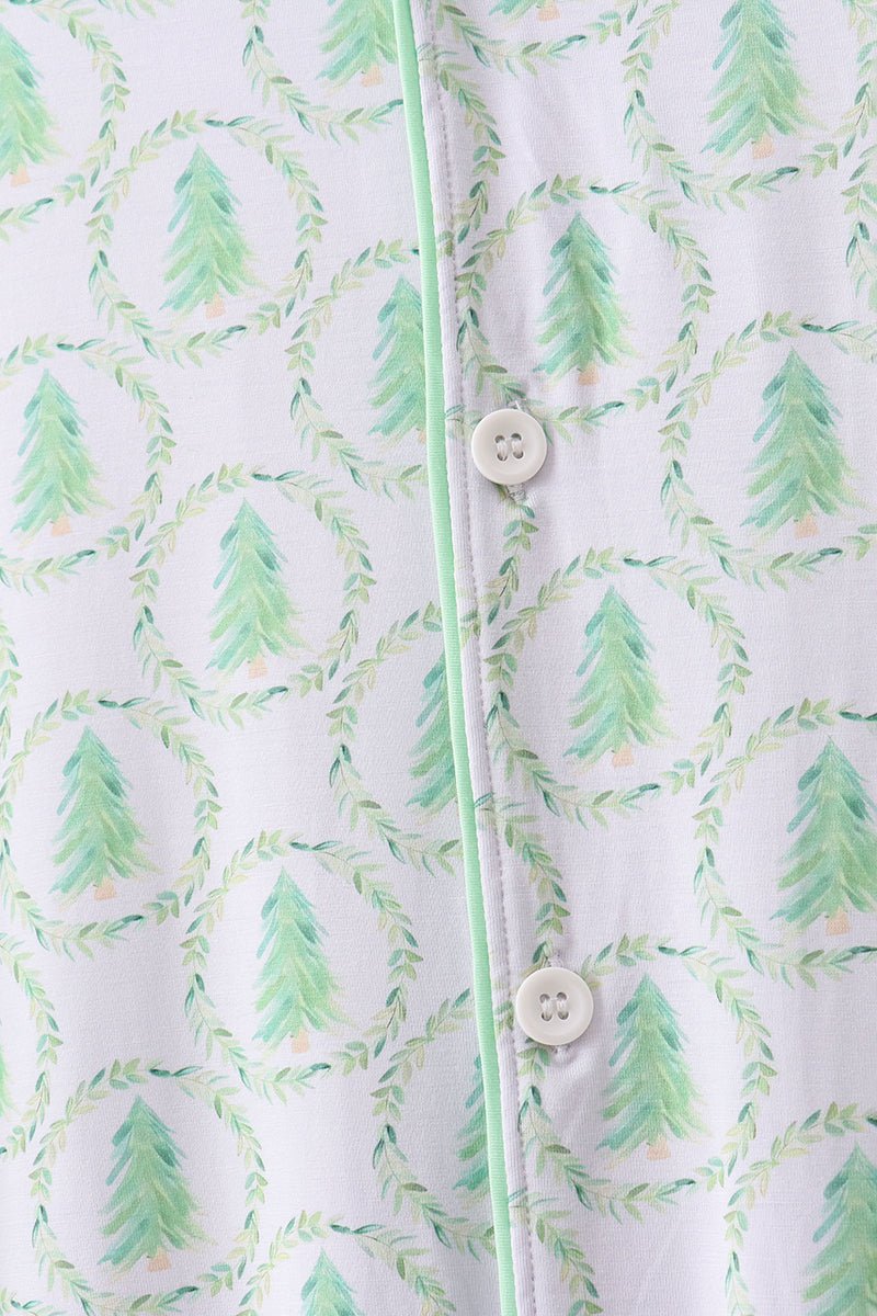 Close-up of a shirt with green tree pattern and buttons on a white background