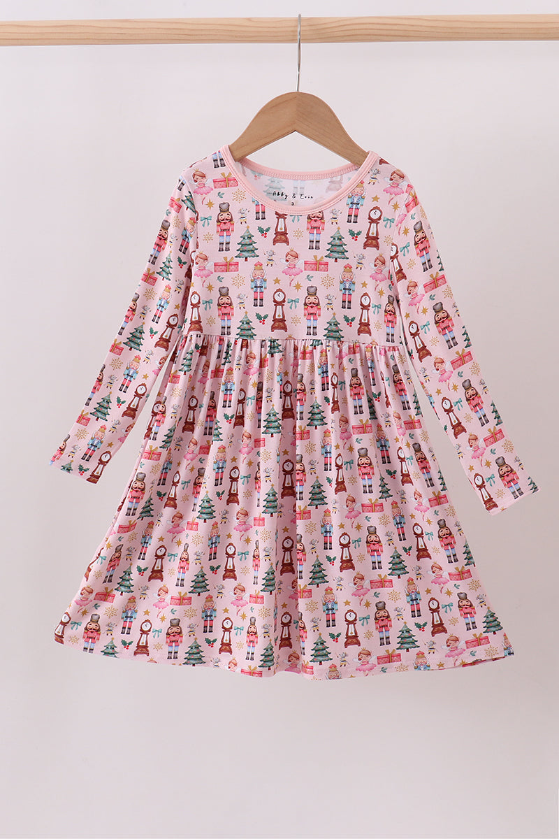 Children's dress with Christmas tree and gift print on a hanger against a white background