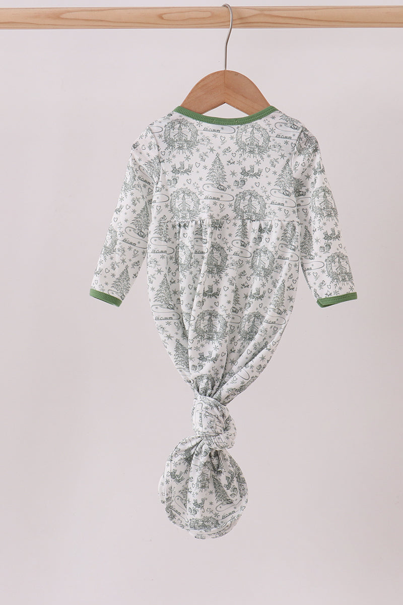 Baby onesie with green and white pattern on a hanger against a light background