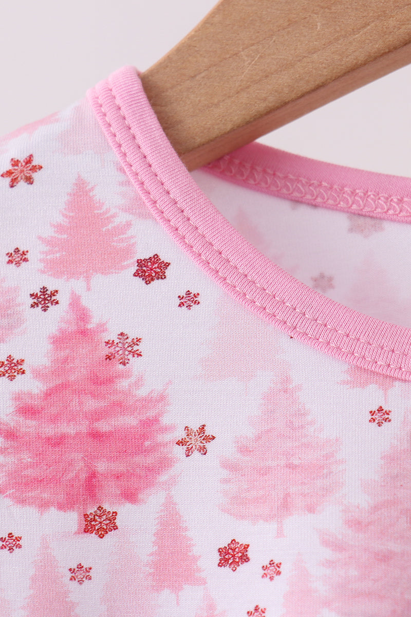 Close-up of a baby outfit with pink trees and snowflakes on a white background.