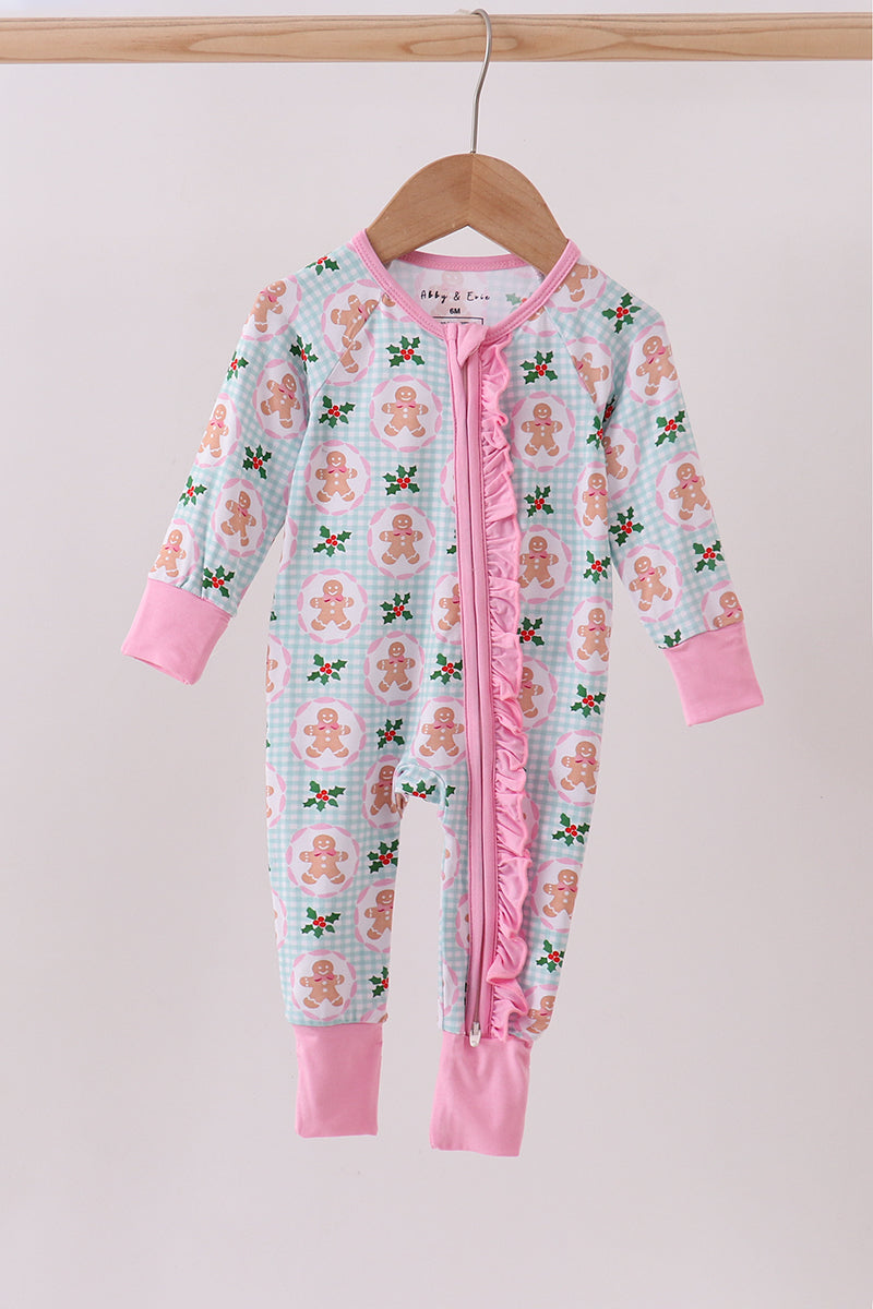 Children's onesie with gingerbread man pattern on a hanger against a light background