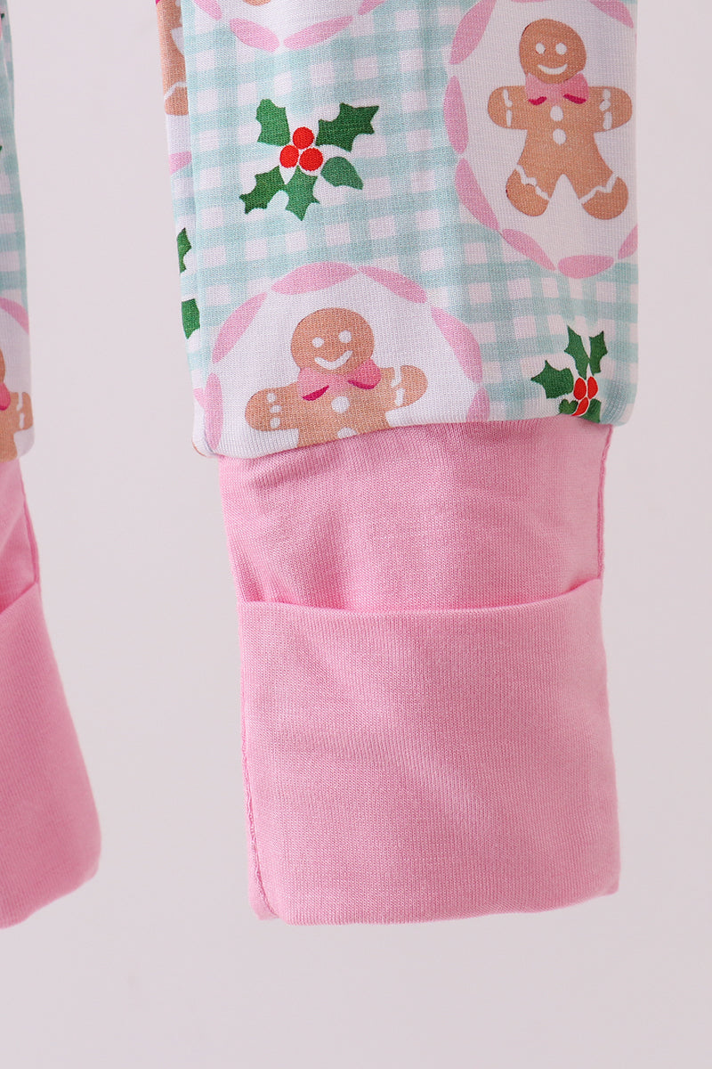 Pink apron with gingerbread man and holly design on a light pink background