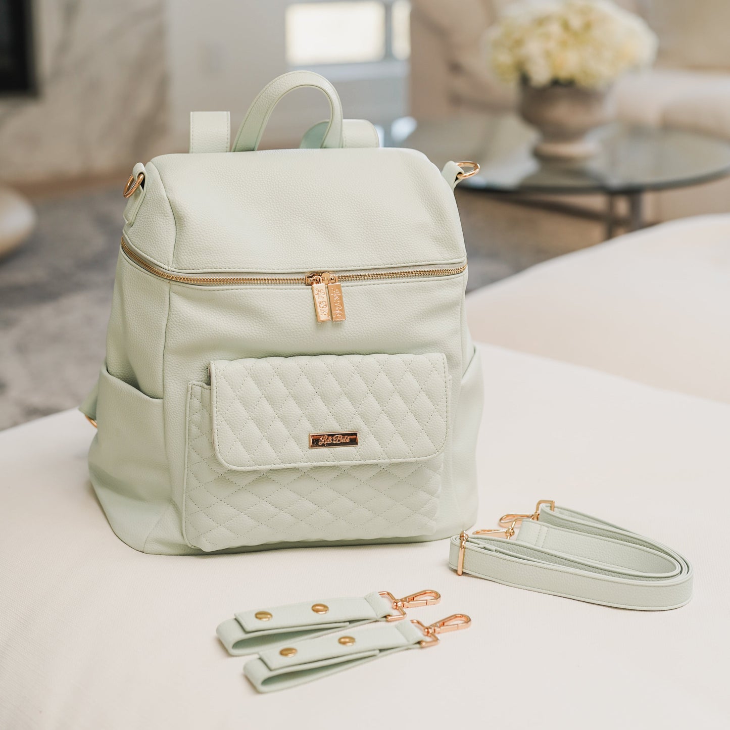 Light green backpack with matching strap and pouch on a white surface.