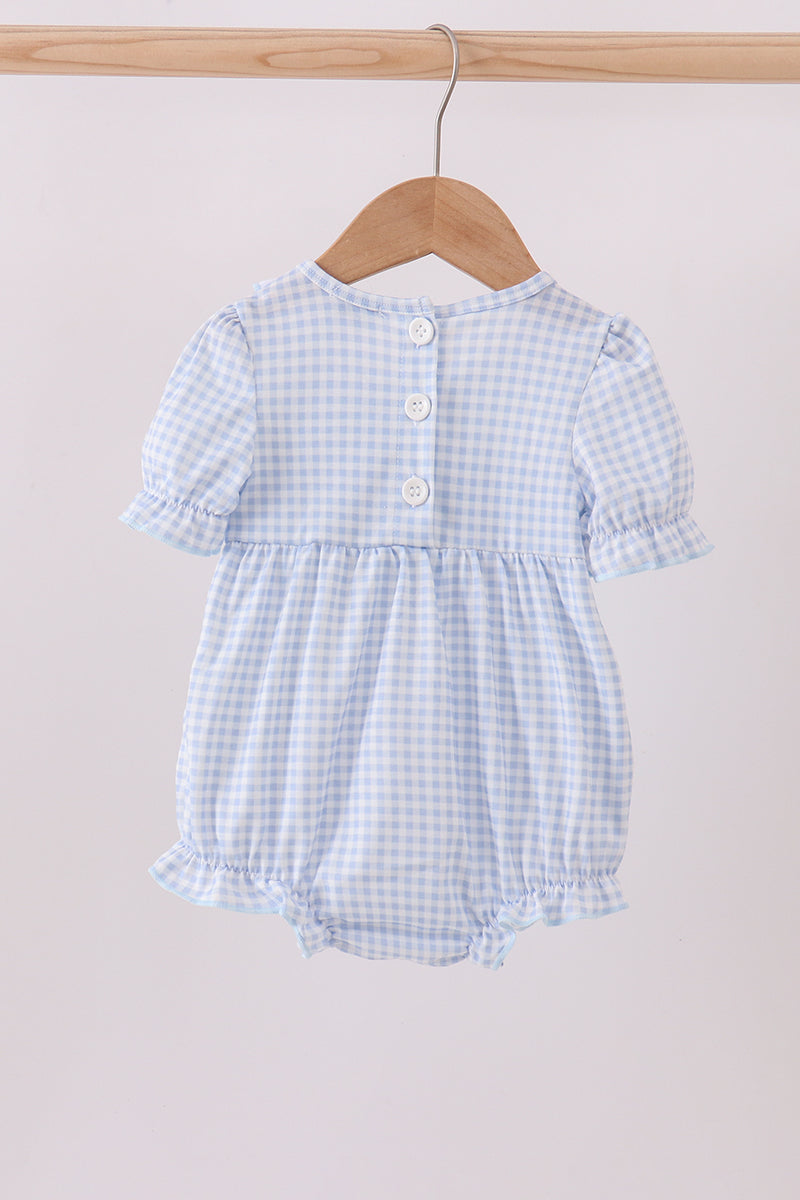 Blue checkered baby romper on a wooden hanger against a light background