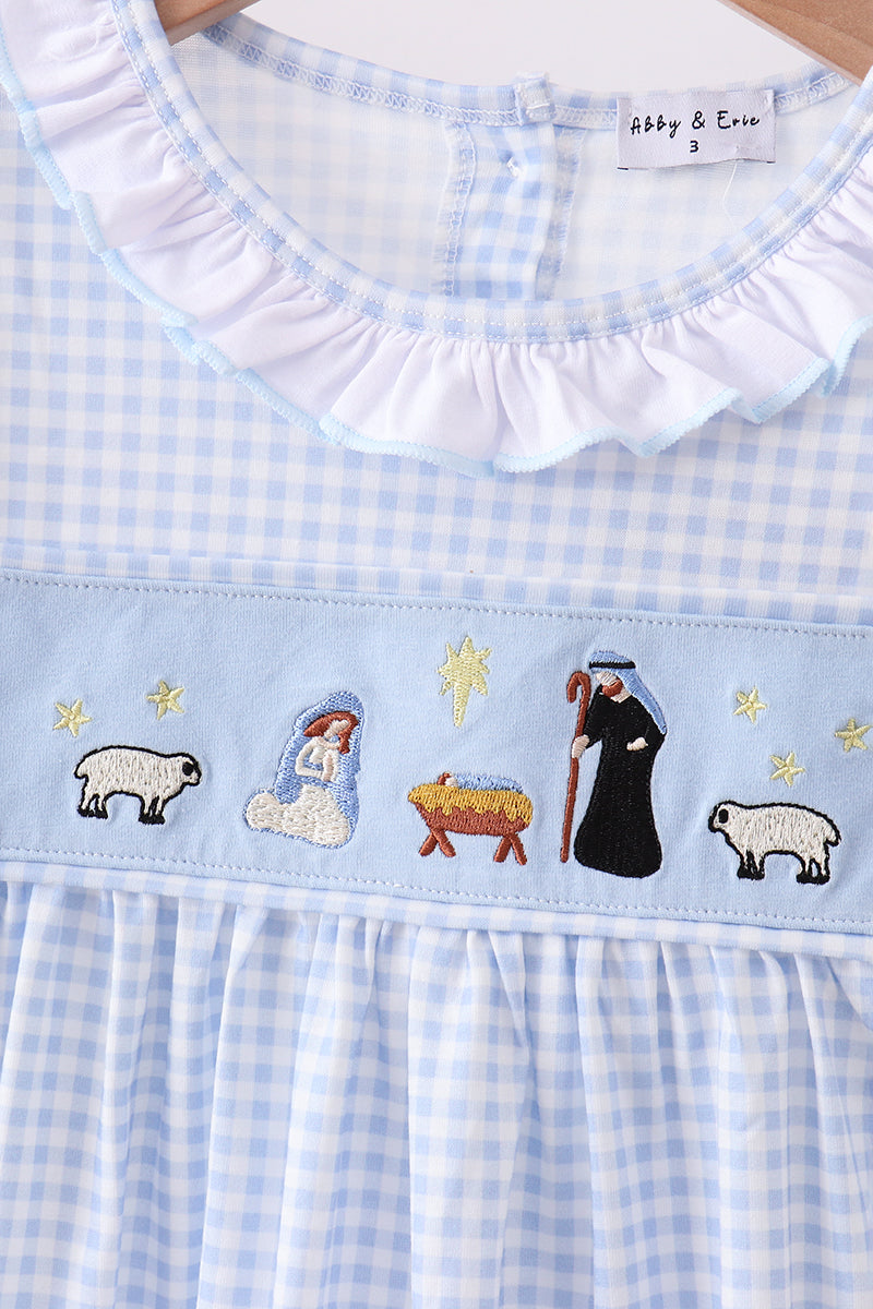 Light blue checkered dress with nativity scene embroidery, brand 'Abby & Ava' visible.